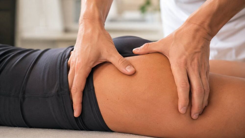 Behandelaar geeft gerichte druk op de bilspier bij piriformissyndroom - Spine Clinics