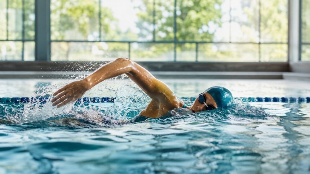 Zwemmer doet de borstcrawl in het zwembad - Spine Clinics
