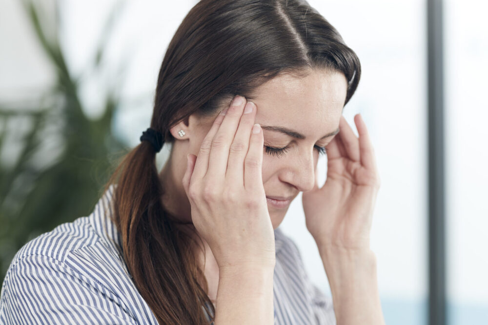 Vrouw met spanningshoofdpijn door stress – Spine Clinics